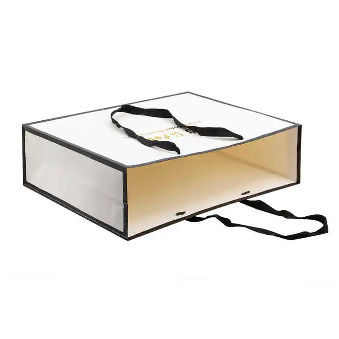 Bolsas de papel de compras blancas para estampado de logotipo minorista boutique con sellos de oro y manijas de cinta